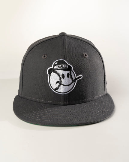 Front profile of a graphite crown with green undervisor New Era Charleston Charlies 59Fifty fitted hat with a white logo on the front.