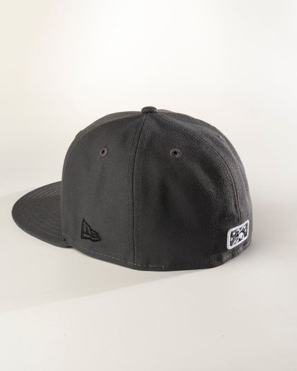 Rear profile of a graphite crown with green undervisor New Era Charleston Charlies 59Fifty fitted hat with a white logo on the front.